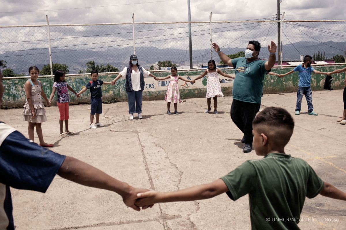 Edras Levi Suazo, 23-years-old, in charge of communications at Jovenes Contra la Violencia (JCV) plays with children of the community during a JCV acitivity in Nueva Capital, Honduras.